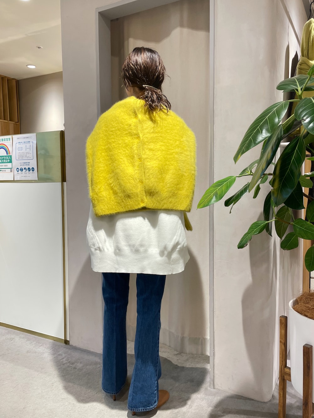 ブルー系のデニムパンツ、ホワイト系のニット/セーター、イエロー系のカーディガン/ボレロを着用したレディースの秋コーディネートの5枚目の写真