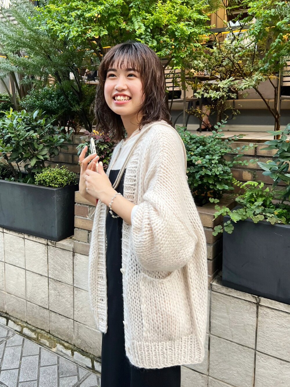 ホワイト系のカーディガン/ボレロ、ブラック系のワンピース、ブラック系のバレエシューズを着用したレディースの秋コーディネートの3枚目の写真