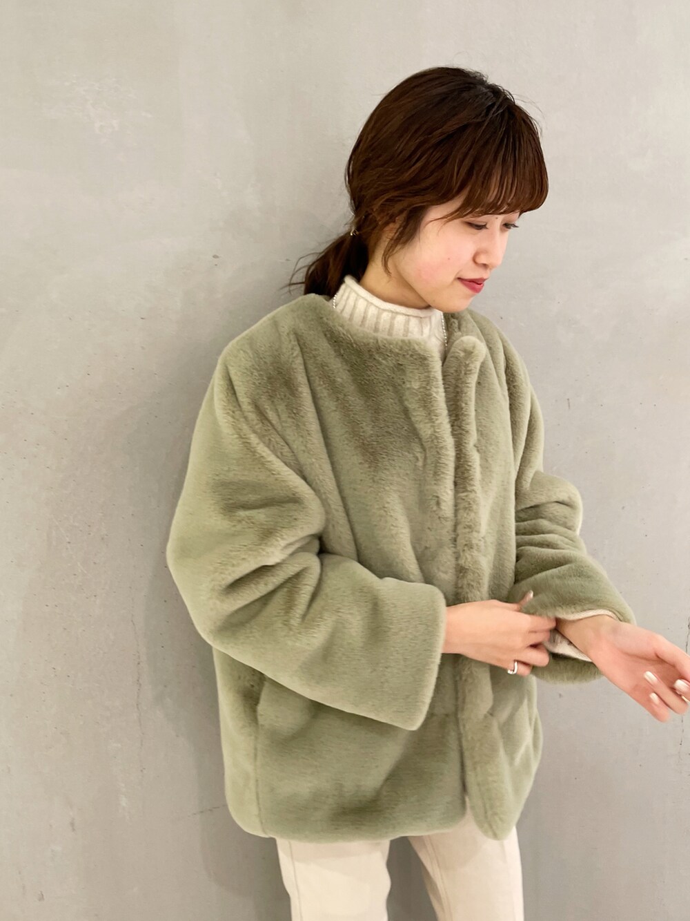 ベージュ系のデニムパンツ、グリーン系のその他アウター、ホワイト系のニット/セーターを着用したレディースの秋コーディネートの3枚目の写真