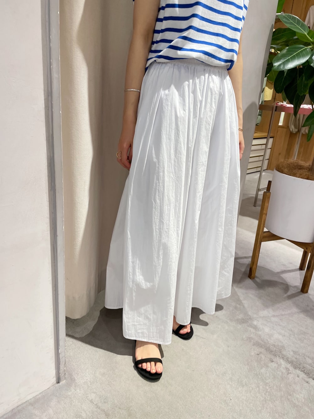 ホワイト系のスカート、ブラック系のサンダル、ブルー系のTシャツ/カットソーを着用したレディースの夏コーディネートの4枚目の写真