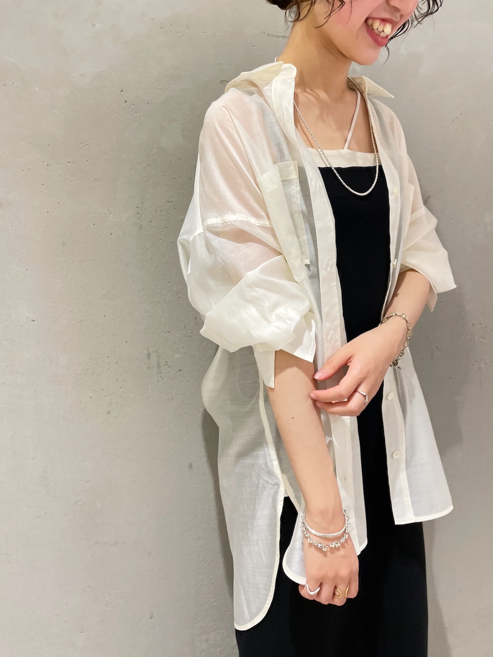 ホワイト系のシャツ/ブラウス、ブラック系のワンピース、ブラック系のサンダルを着用したレディースの夏コーディネートの3枚目の写真