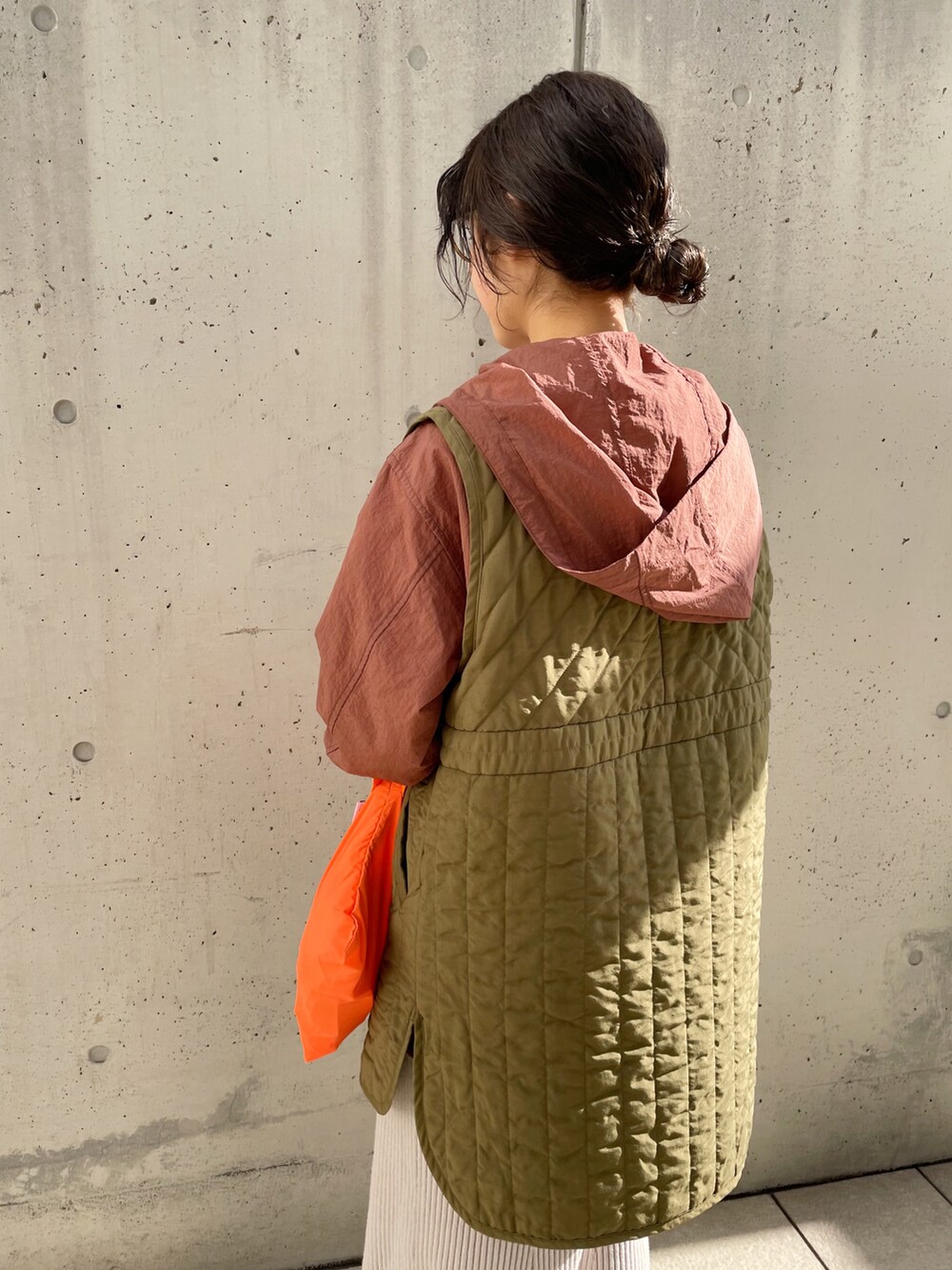 グレー系のスカート、グリーン系のベスト、ブラウン系のブルゾンを着用したレディースの冬コーディネートの3枚目の写真