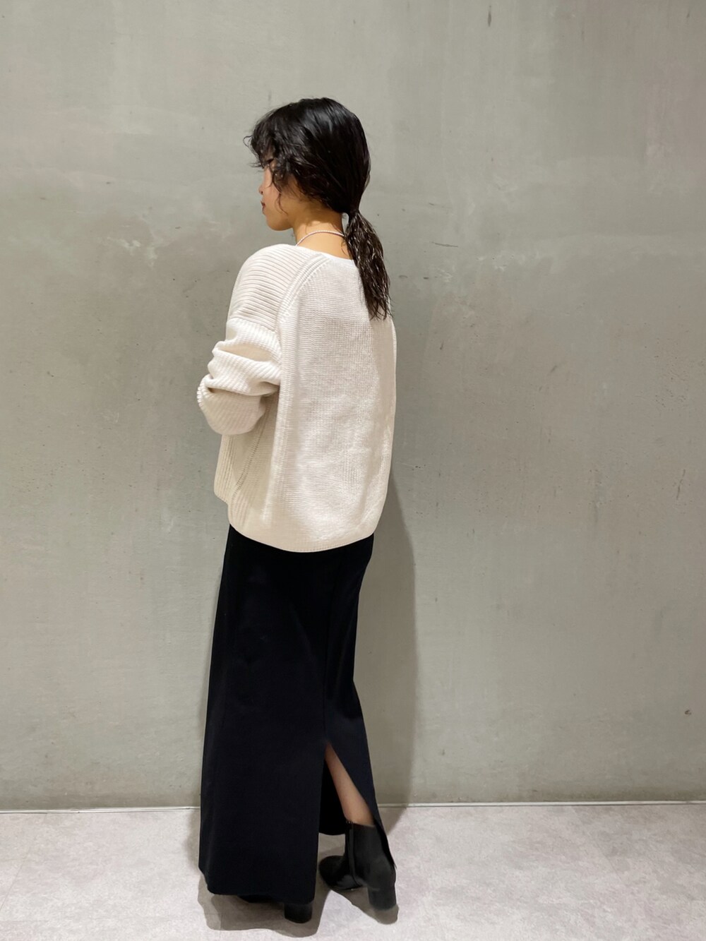 ホワイト系のニット/セーター、ブラック系のワンピース、ブラック系のブーツを着用したレディースの秋コーディネートの4枚目の写真