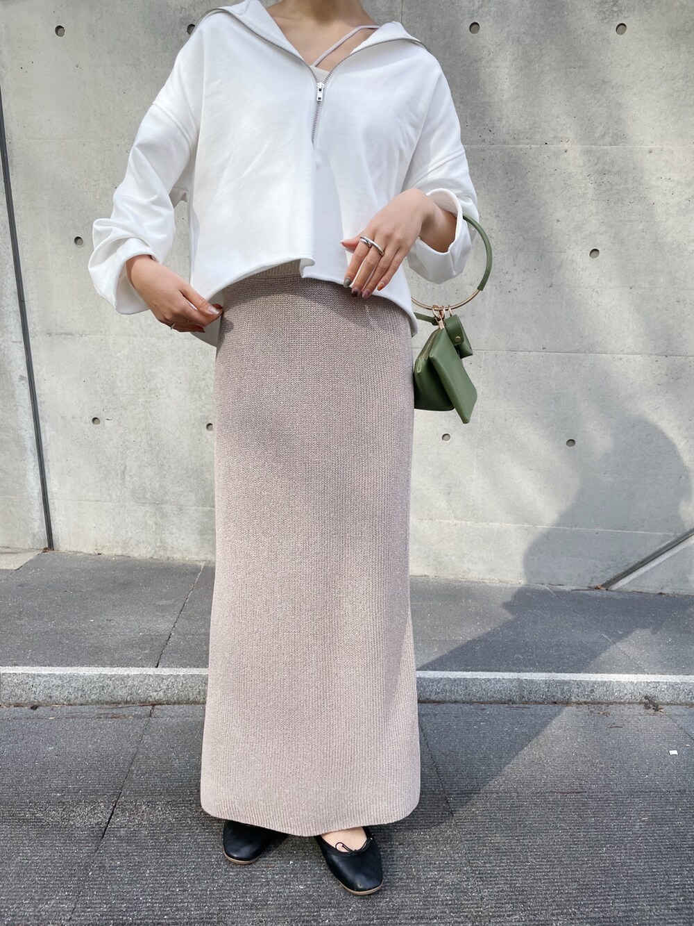 グレー系のスカート、ブラック系のバレエシューズ、ホワイト系のスウェットを着用したレディースの春コーディネートの4枚目の写真