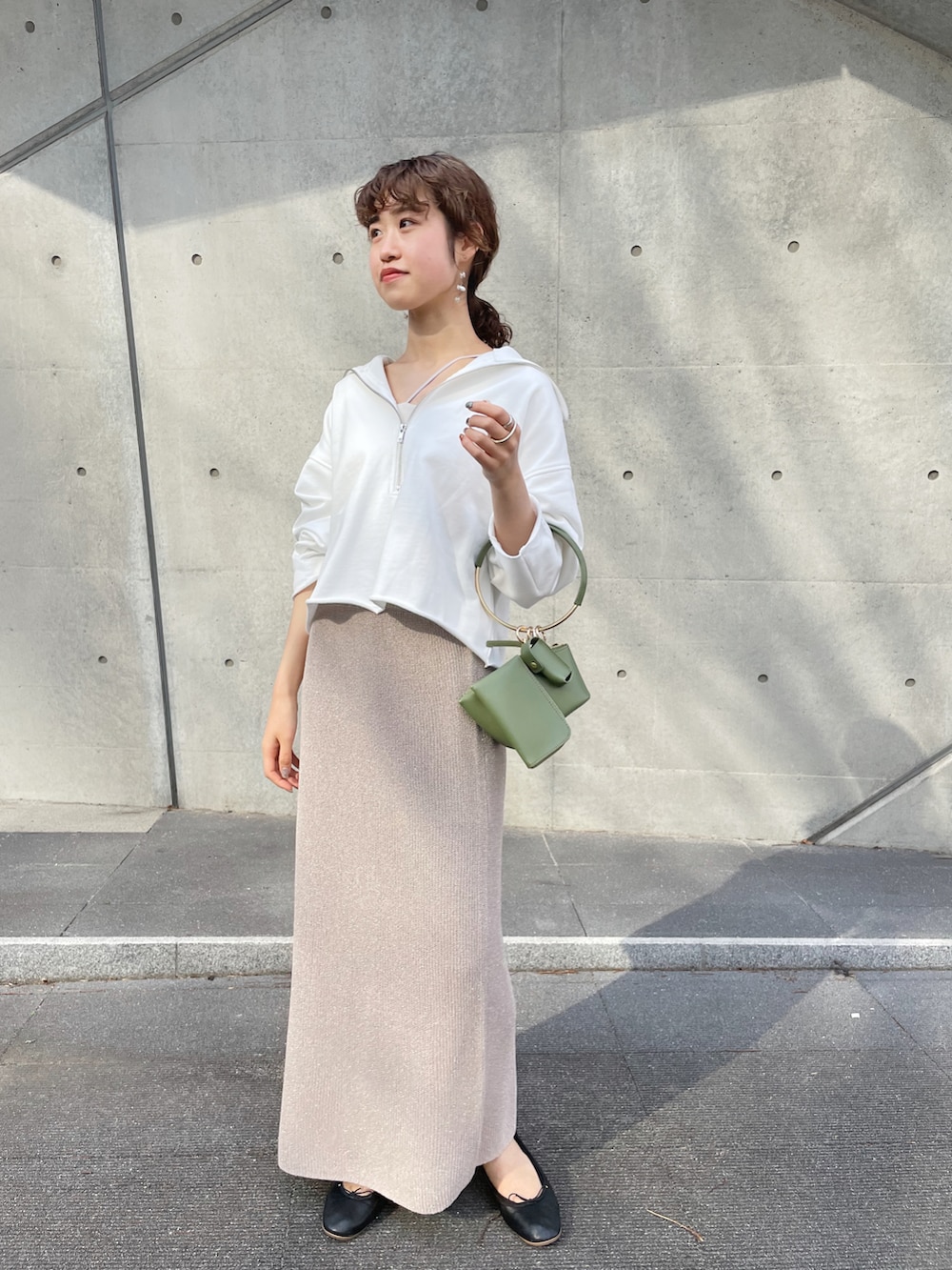 グレー系のスカート、ブラック系のバレエシューズ、ホワイト系のスウェットを着用したレディースの春コーディネートの2枚目の写真