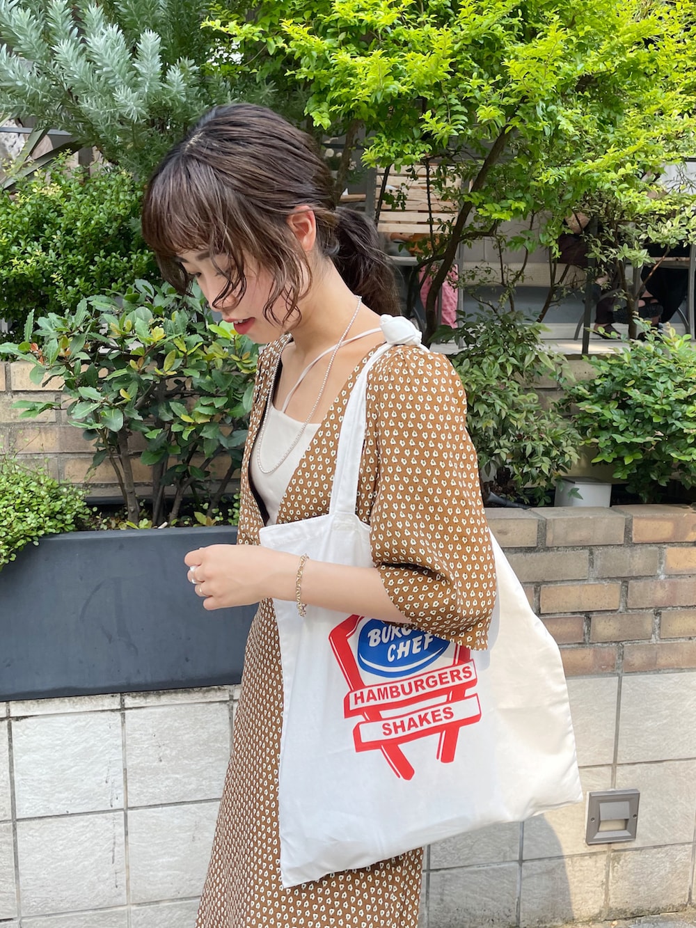 ブラウン系のワンピース、ブラック系のサンダル、ホワイト系のトートバッグを着用したレディースの夏コーディネートの4枚目の写真