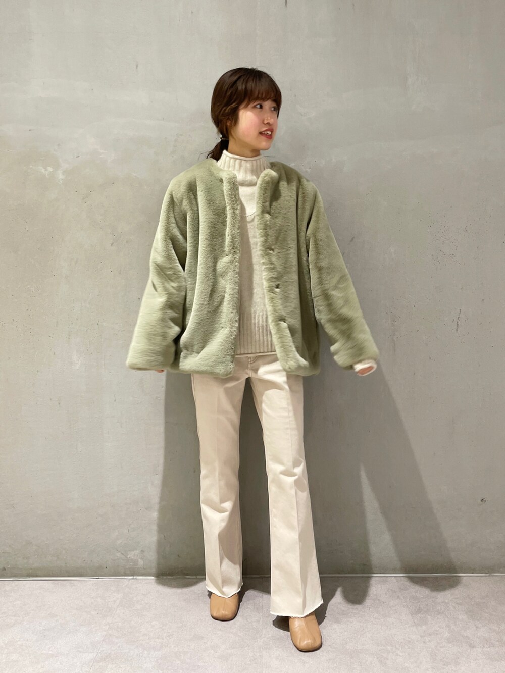 ベージュ系のデニムパンツ、グリーン系のその他アウター、ホワイト系のニット/セーターを着用したレディースの秋コーディネートの2枚目の写真