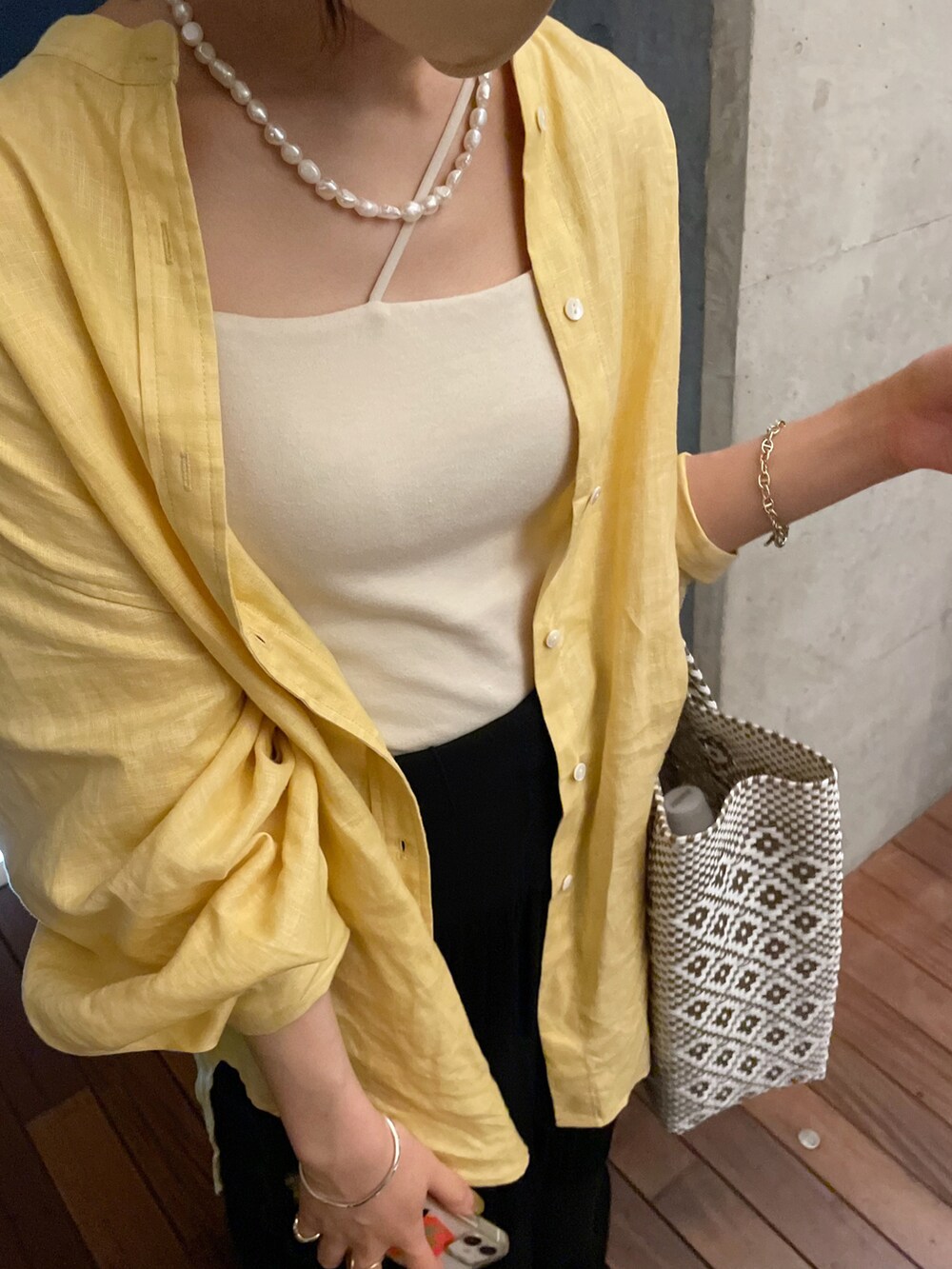 イエロー系のシャツ/ブラウス、ブラック系のスカート、ブラック系のサンダルを着用したレディースの夏コーディネートの4枚目の写真