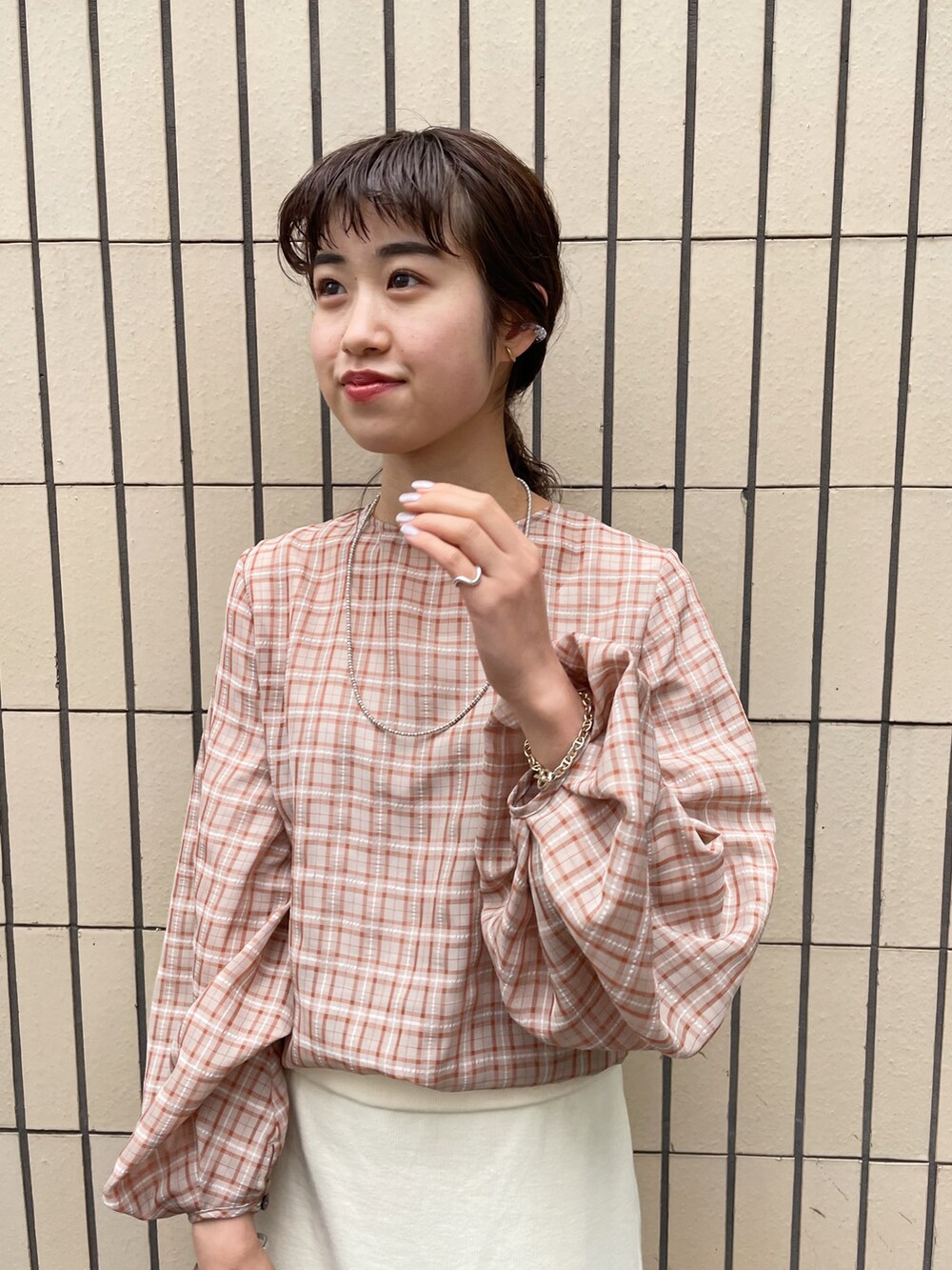 ブラック系のサンダル、オレンジ系のシャツ/ブラウス、ホワイト系のスカートを着用したレディースの春コーディネートの3枚目の写真