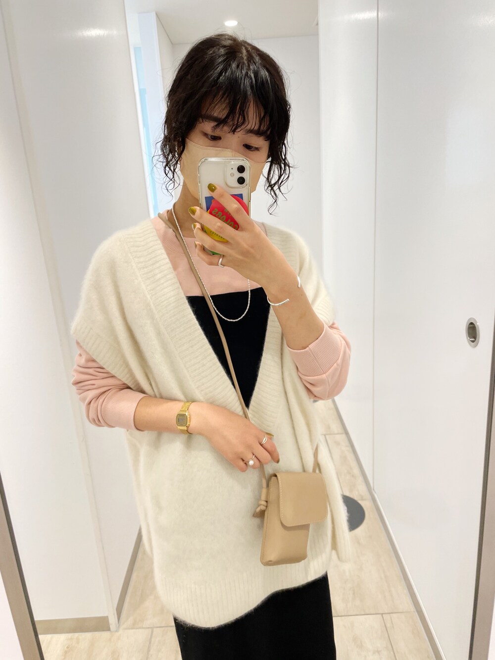 ブラック系のワンピース、ピンク系のスウェット、ホワイト系のベストを着用したレディースの秋コーディネートの2枚目の写真