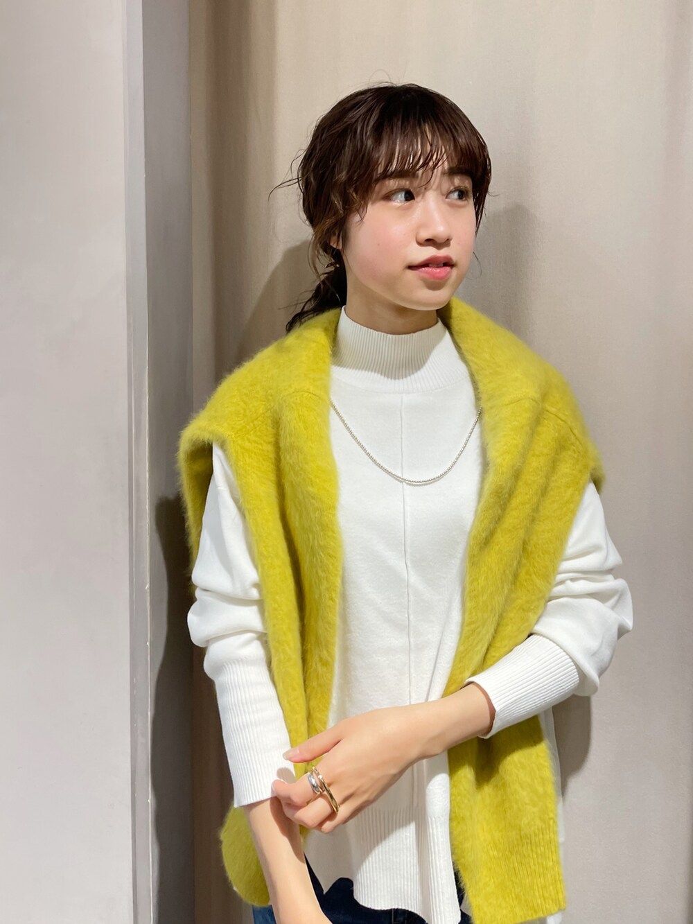 ブルー系のデニムパンツ、ホワイト系のニット/セーター、イエロー系のカーディガン/ボレロを着用したレディースの秋コーディネートの2枚目の写真