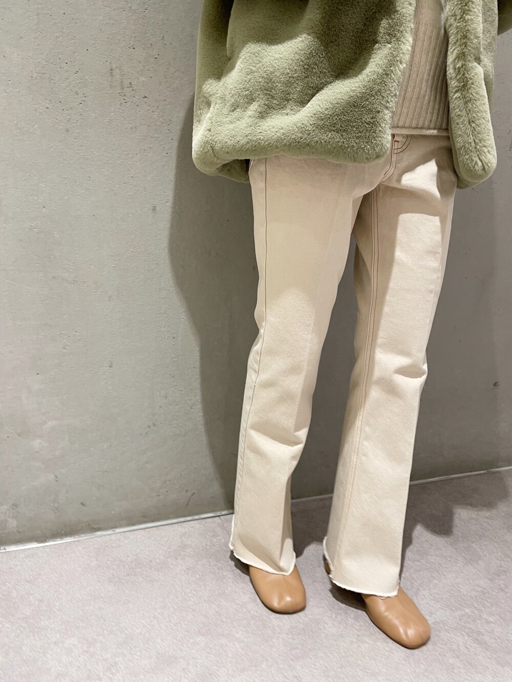 ベージュ系のデニムパンツ、グリーン系のその他アウター、ホワイト系のニット/セーターを着用したレディースの秋コーディネートの4枚目の写真