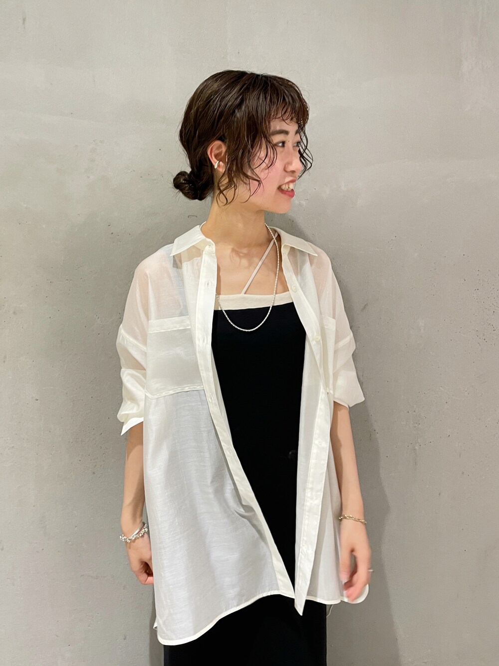 ホワイト系のシャツ/ブラウス、ブラック系のワンピース、ブラック系のサンダルを着用したレディースの夏コーディネートの2枚目の写真