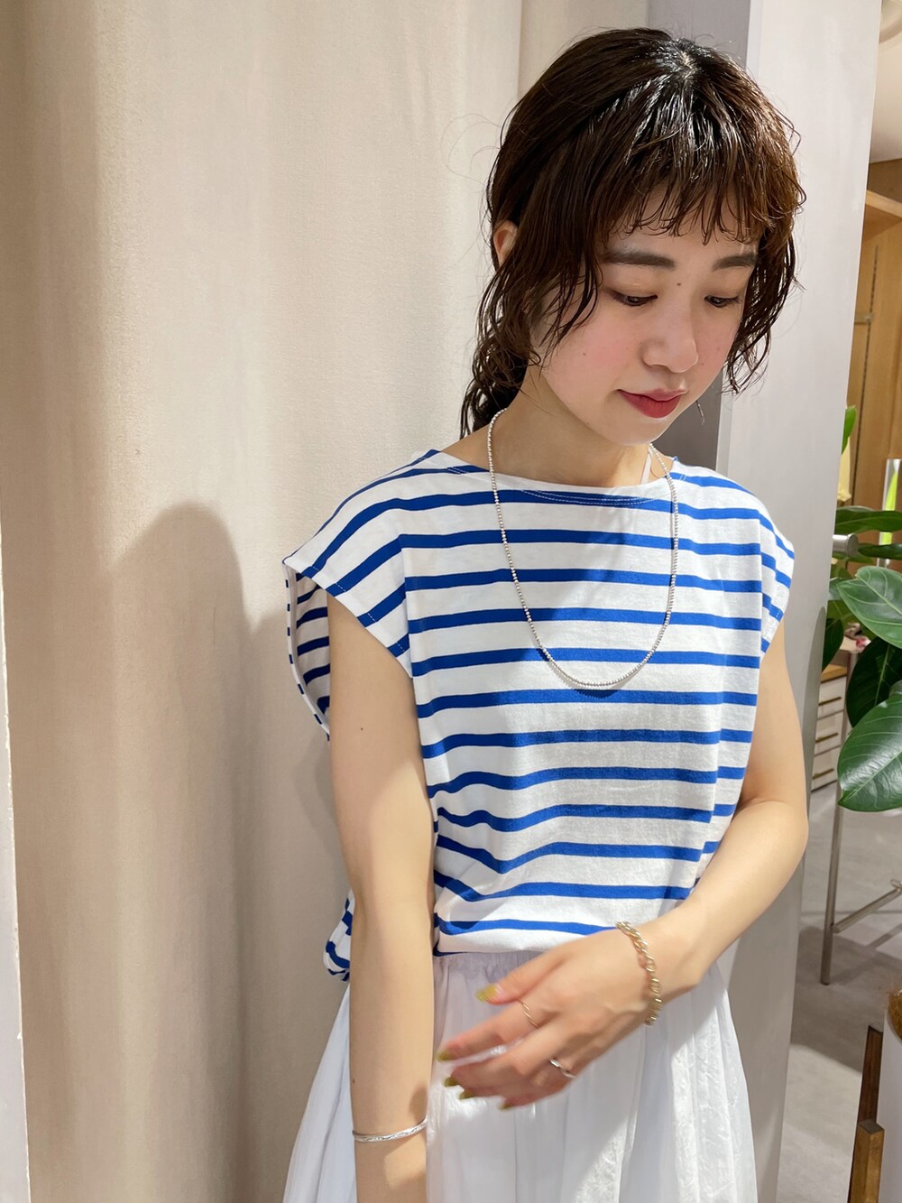 ホワイト系のスカート、ブラック系のサンダル、ブルー系のTシャツ/カットソーを着用したレディースの夏コーディネートの3枚目の写真