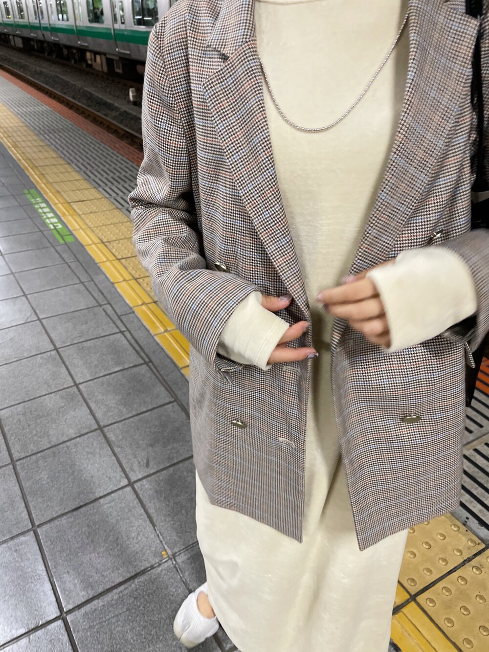 ベージュ系のテーラードジャケット、ベージュ系のワンピース、ホワイト系のスニーカーを着用したレディースの秋コーディネートの3枚目の写真