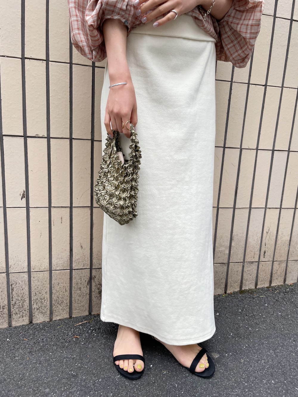 ブラック系のサンダル、オレンジ系のシャツ/ブラウス、ホワイト系のスカートを着用したレディースの春コーディネートの5枚目の写真