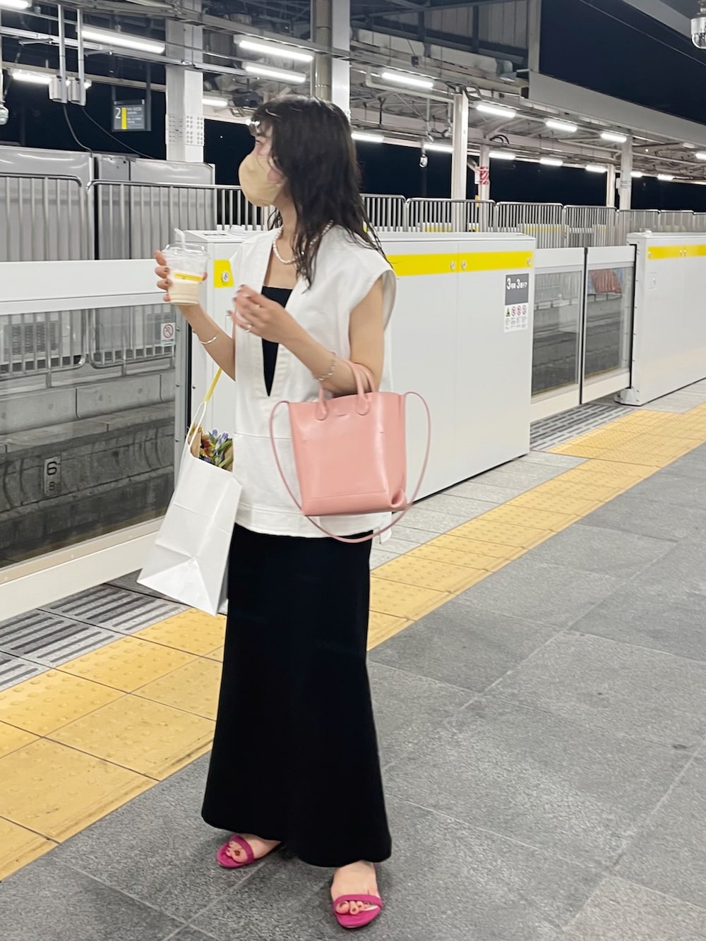 ピンク系のサンダル、ブラック系のワンピース、ホワイト系のベストを着用したレディースの夏コーディネートの5枚目の写真