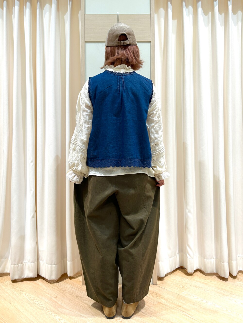 ブルー系のベスト、ホワイト系のシャツ/ブラウス、グリーン系のその他パンツを着用したレディースの秋コーディネートの2枚目の写真