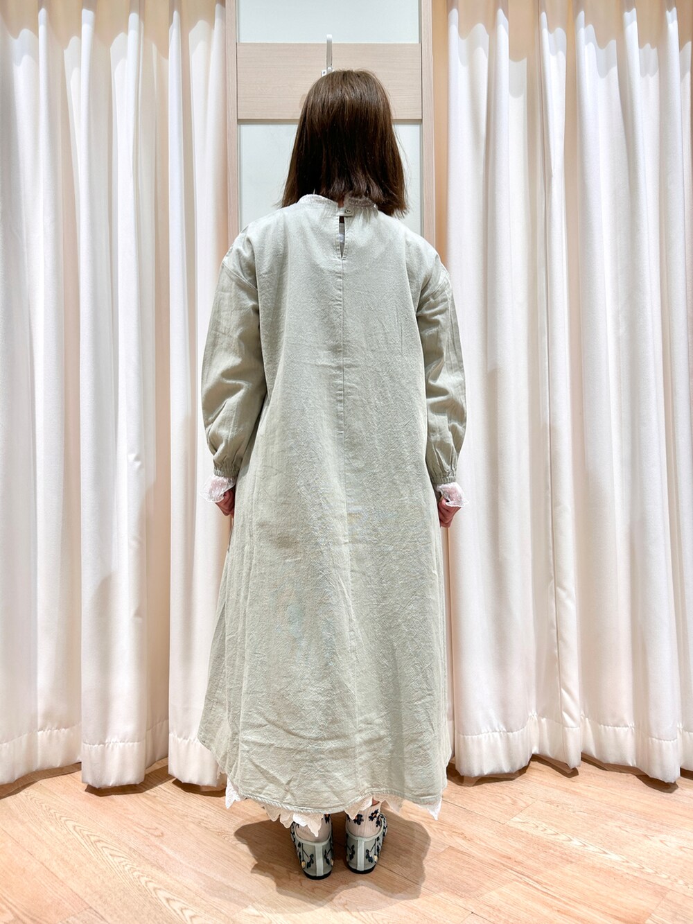 ブラウン系のハンドバッグ、グリーン系のドレスシューズ、グリーン系のワンピース/ドレスを着用したレディースの冬コーディネートの2枚目の写真