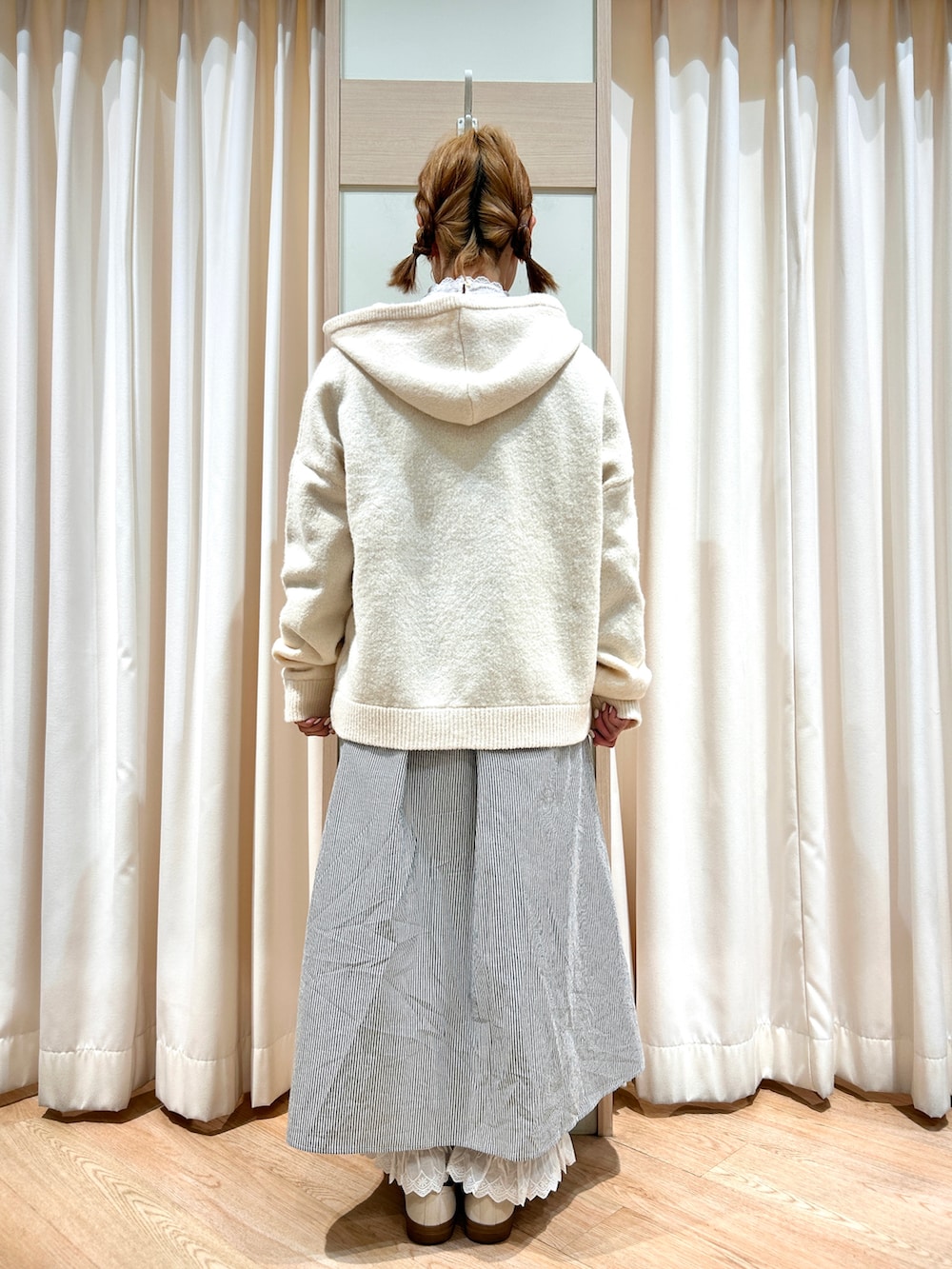 ホワイト系のカーディガン/ボレロ、ブラック系のワンピース、ホワイト系のTシャツ/カットソーを着用したレディースの冬コーディネートの2枚目の写真