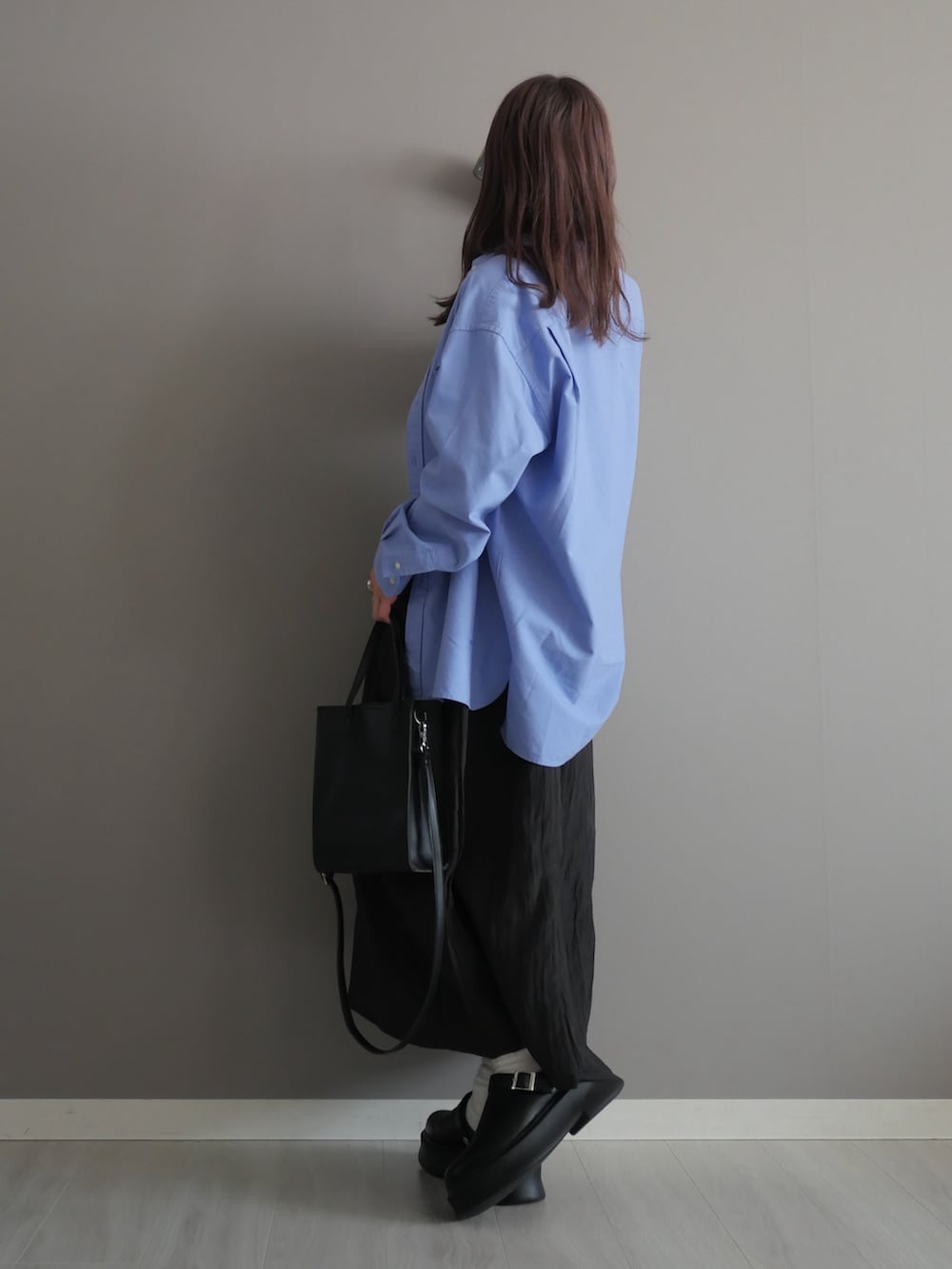 ホワイト系のタンクトップ、ブラック系のワンピース、ブラック系のショルダーバッグを着用したレディースの春コーディネートの3枚目の写真