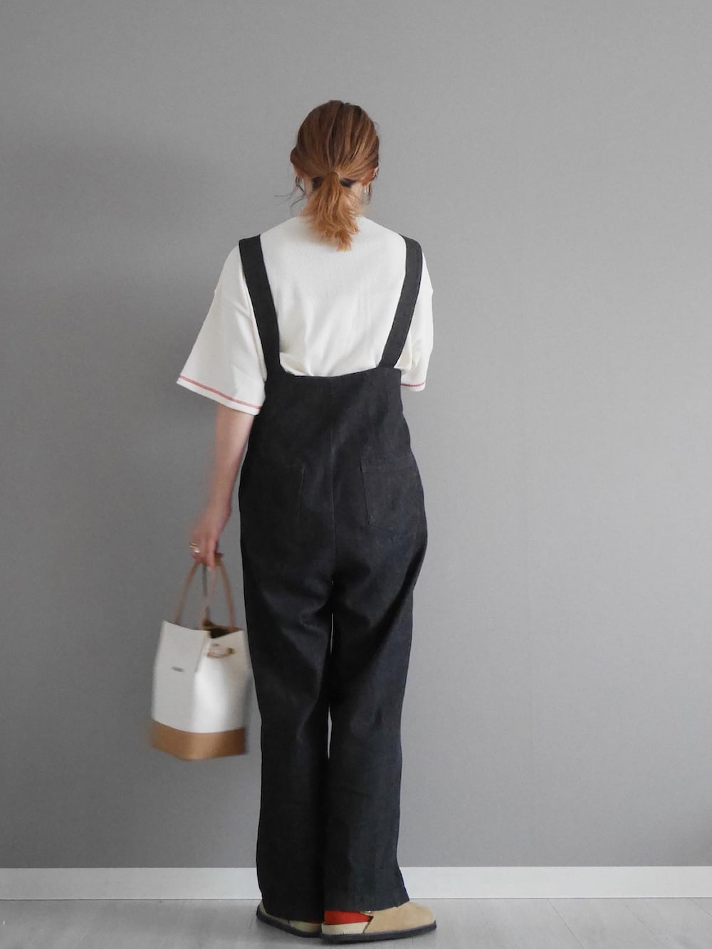 ホワイト系のTシャツ/カットソー、ブラック系のサロペット/オーバーオール、ホワイト系のハンドバッグを着用したレディースの春コーディネートの2枚目の写真