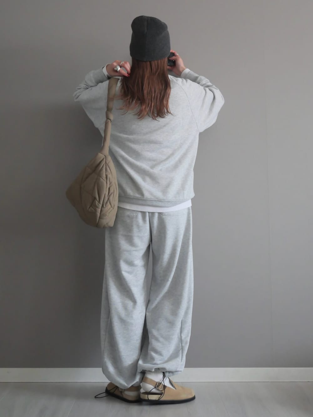 グレー系のスウェット、グレー系のスウェットパンツ、ブラウン系のメッセンジャーバッグを着用したレディースの冬コーディネートの5枚目の写真