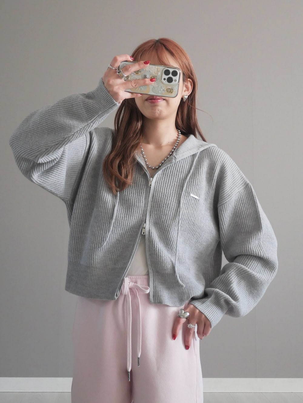 グレー系のパーカー、シルバー系のボディバッグ/ウエストポーチを着用したレディースの冬コーディネートの2枚目の写真