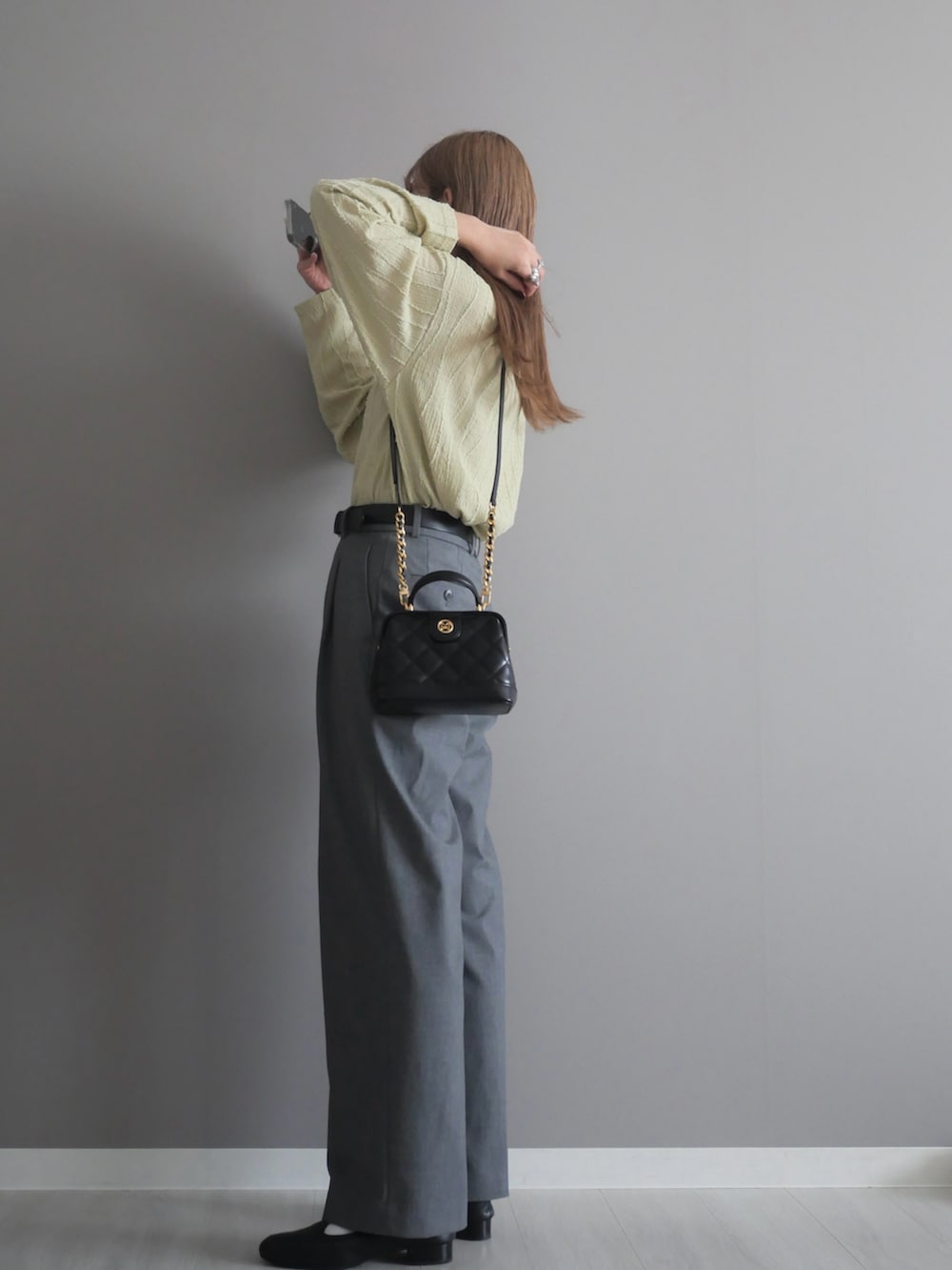 ブラック系のトートバッグ、グリーン系のTシャツ/カットソー、ブラック系のパンプスを着用したレディースの秋コーディネートの4枚目の写真