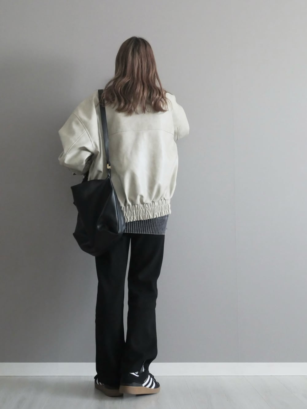 ホワイト系のブルゾン、ブラック系のニット/セーター、ブラック系のその他パンツを着用したレディースの冬コーディネートの5枚目の写真