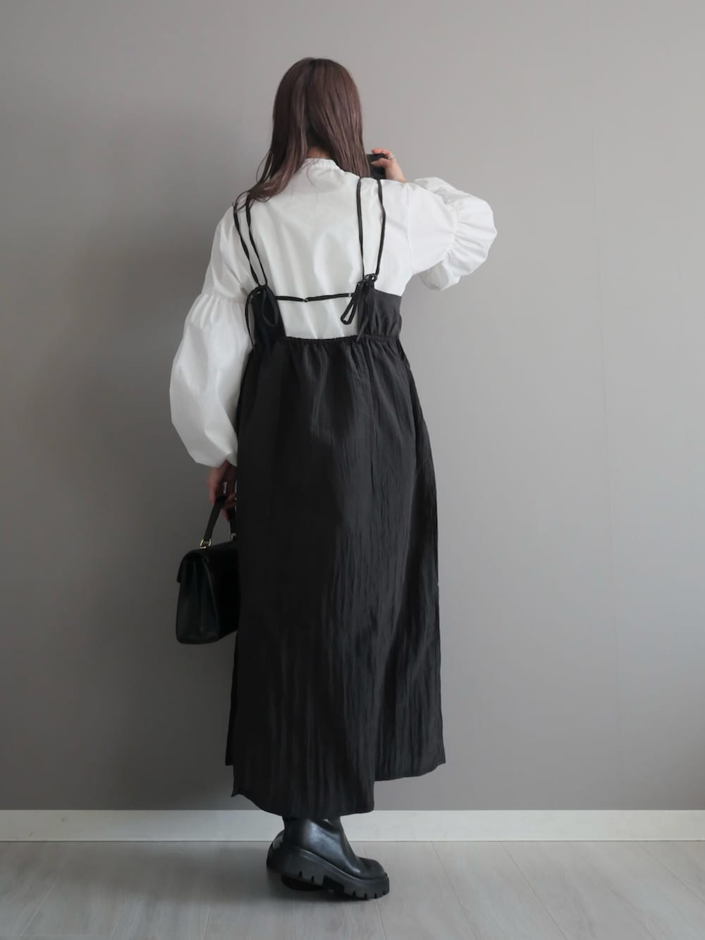 ブラック系のトートバッグ、ブラック系のブーツ、ホワイト系のシャツ/ブラウスを着用したレディースの春コーディネートの5枚目の写真