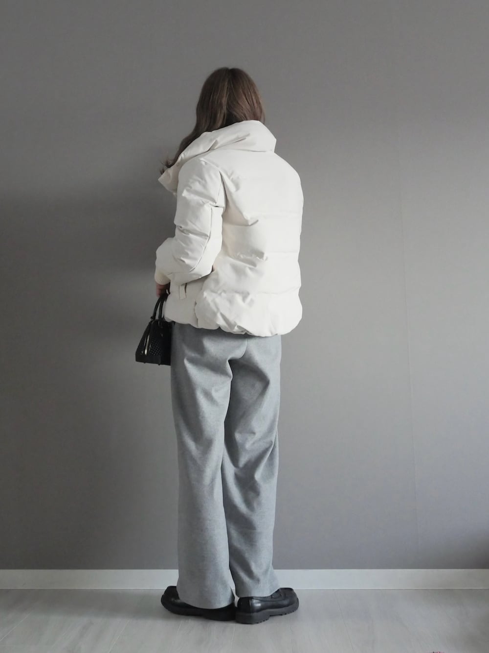 ホワイト系のダウンジャケット/コート、ホワイト系のTシャツ/カットソー、ブラック系のベストを着用したレディースの冬コーディネートの5枚目の写真