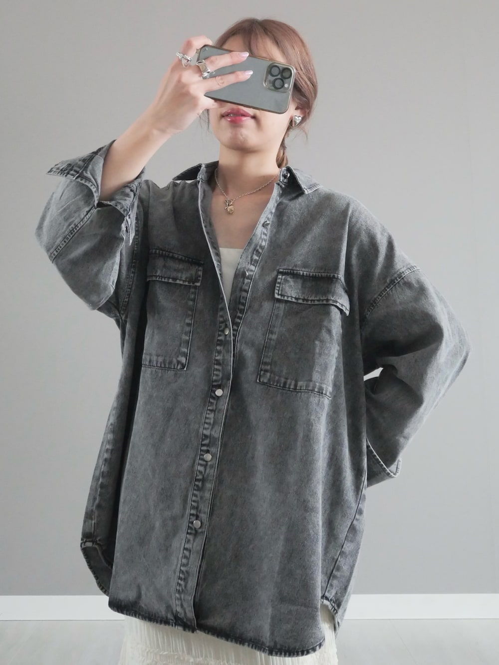 ブラック系のシャツ/ブラウス、ホワイト系のスカート、ホワイト系のハンドバッグを着用したレディースの春コーディネートの2枚目の写真