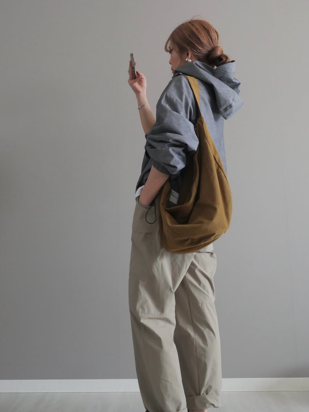 グレー系のシャツ/ブラウス、グリーン系のショルダーバッグ、ベージュ系のパンツを着用したレディースの春コーディネートの5枚目の写真