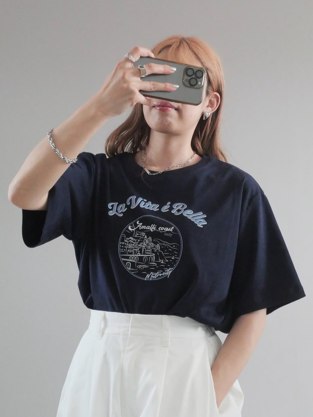 ブルー系のTシャツ/カットソー、ブラック系のトートバッグ、ホワイト系のチノパンツを着用したレディースの夏コーディネートの2枚目の写真