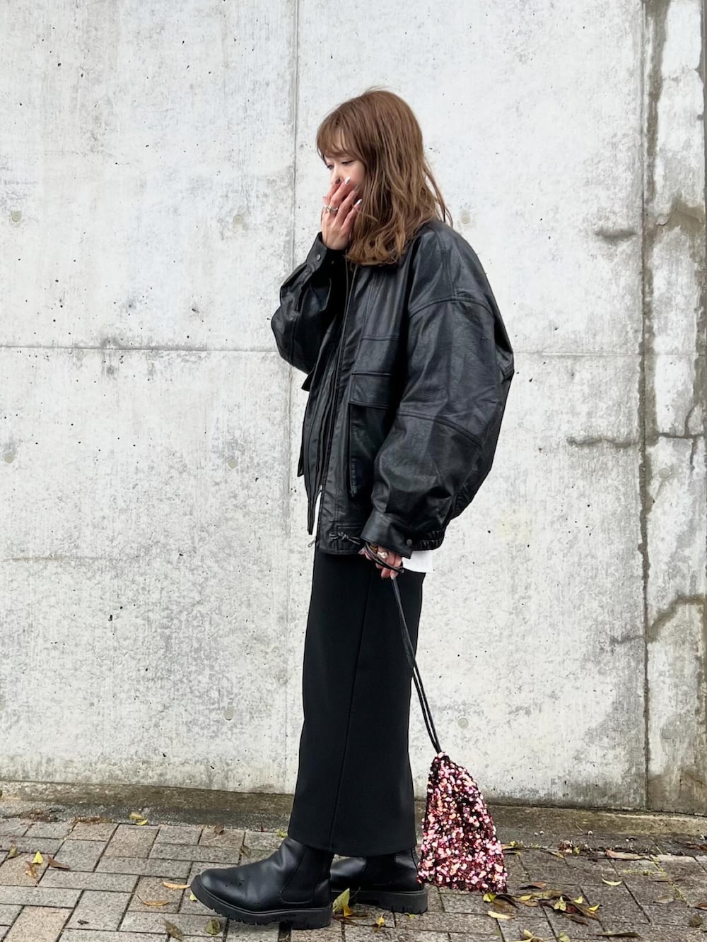 レッド系のショルダーバッグ、ブラック系のトップス、ホワイト系のシャツ/ブラウスを着用したレディースの冬コーディネートの3枚目の写真