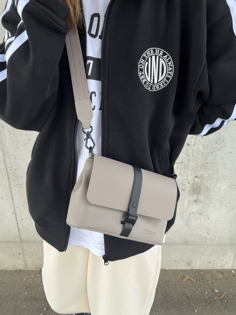 ブラック系のスウェット、ホワイト系のTシャツ/カットソー、ホワイト系のスウェットパンツを着用したレディースの秋コーディネートの2枚目の写真