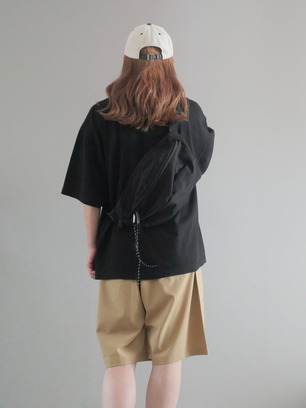 ブラック系のTシャツ/カットソー、ベージュ系のその他パンツ、ブラック系のボディバッグ/ウエストポーチを着用したレディースの夏コーディネートの3枚目の写真