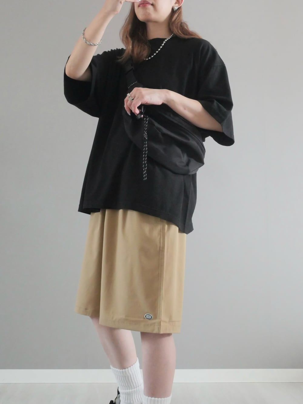 ブラック系のTシャツ/カットソー、ベージュ系のその他パンツ、ブラック系のボディバッグ/ウエストポーチを着用したレディースの夏コーディネートの2枚目の写真