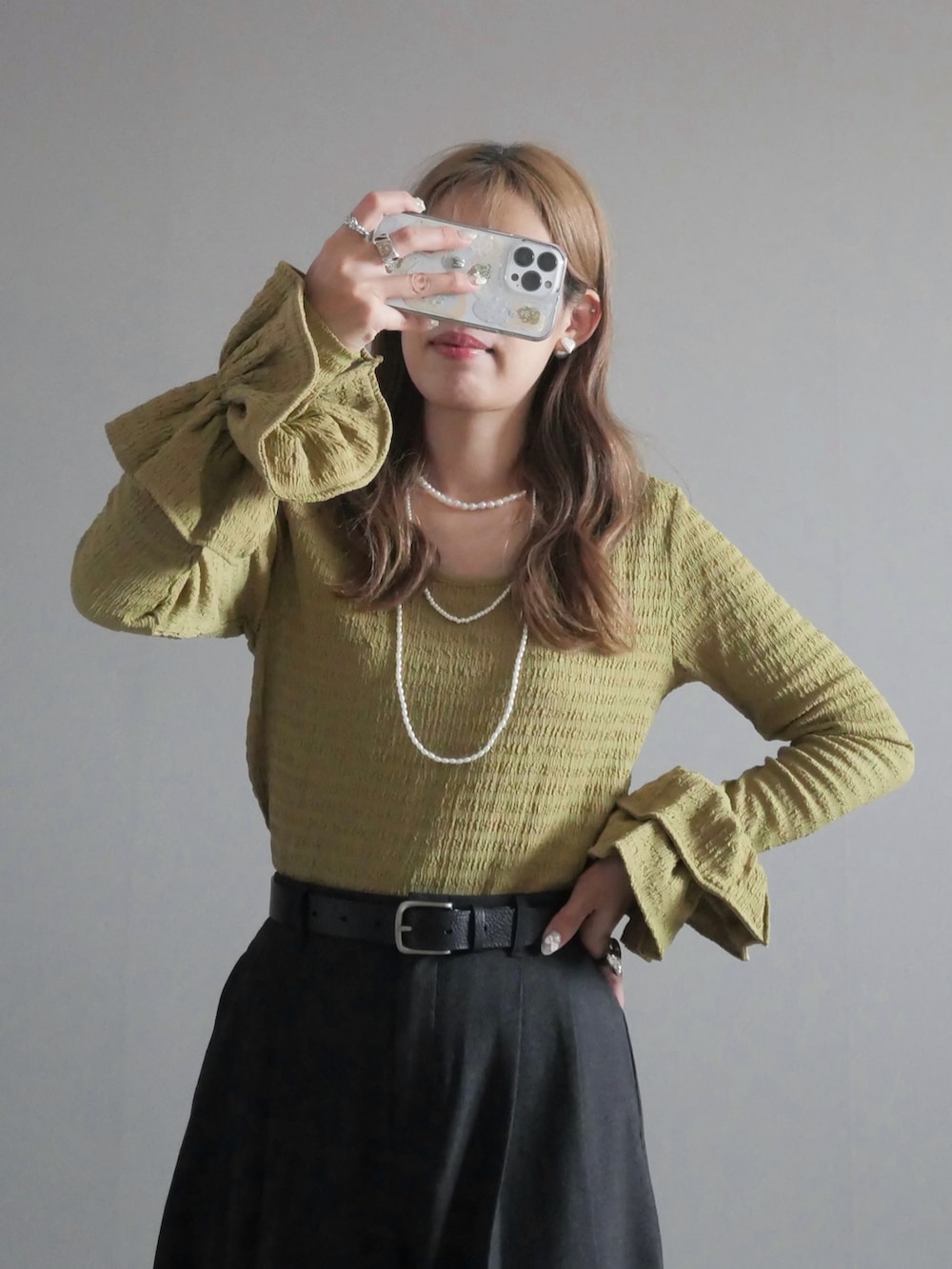 ブラック系のトートバッグ、グリーン系のTシャツ/カットソー、ブラック系のブーツを着用したレディースの秋コーディネートの3枚目の写真