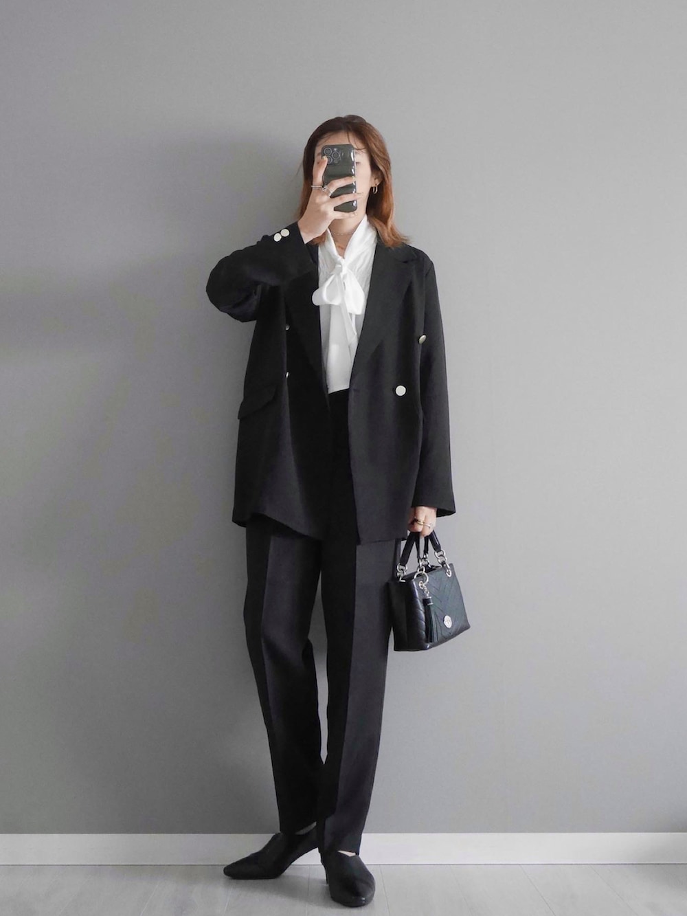 ホワイト系のシャツ/ブラウス、ブラック系のセットアップ、ブラック系のショルダーバッグを着用したレディースの春コーディネートの3枚目の写真