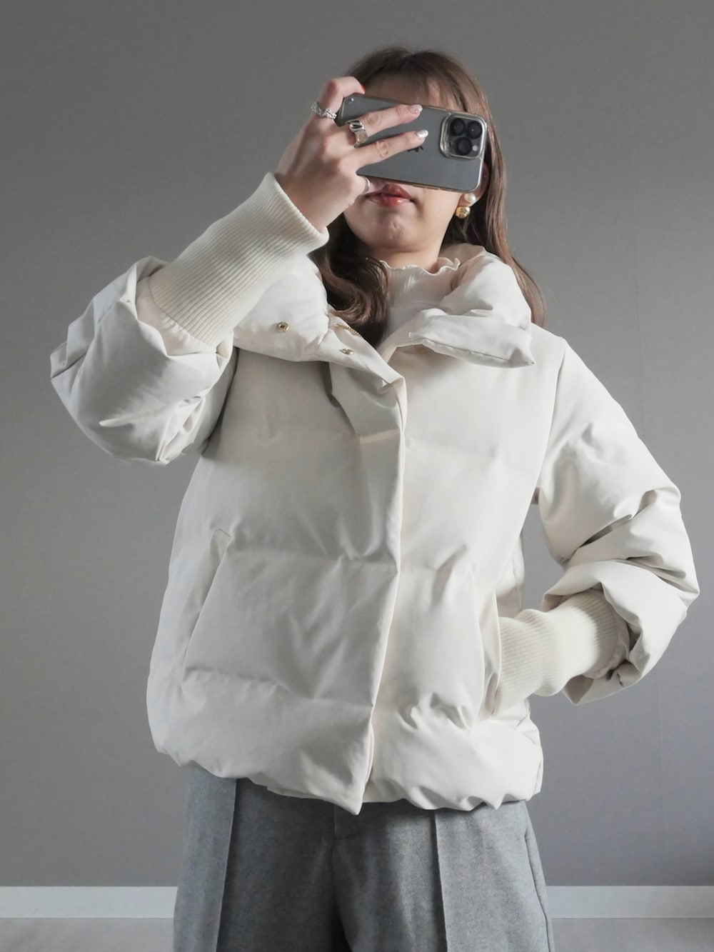 ホワイト系のダウンジャケット/コート、ホワイト系のTシャツ/カットソー、ブラック系のベストを着用したレディースの冬コーディネートの3枚目の写真