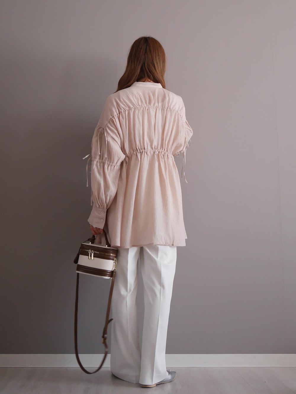 ベージュ系のシャツ/ブラウス、ホワイト系のパンツ、ホワイト系のハンドバッグを着用したレディースの春コーディネートの2枚目の写真