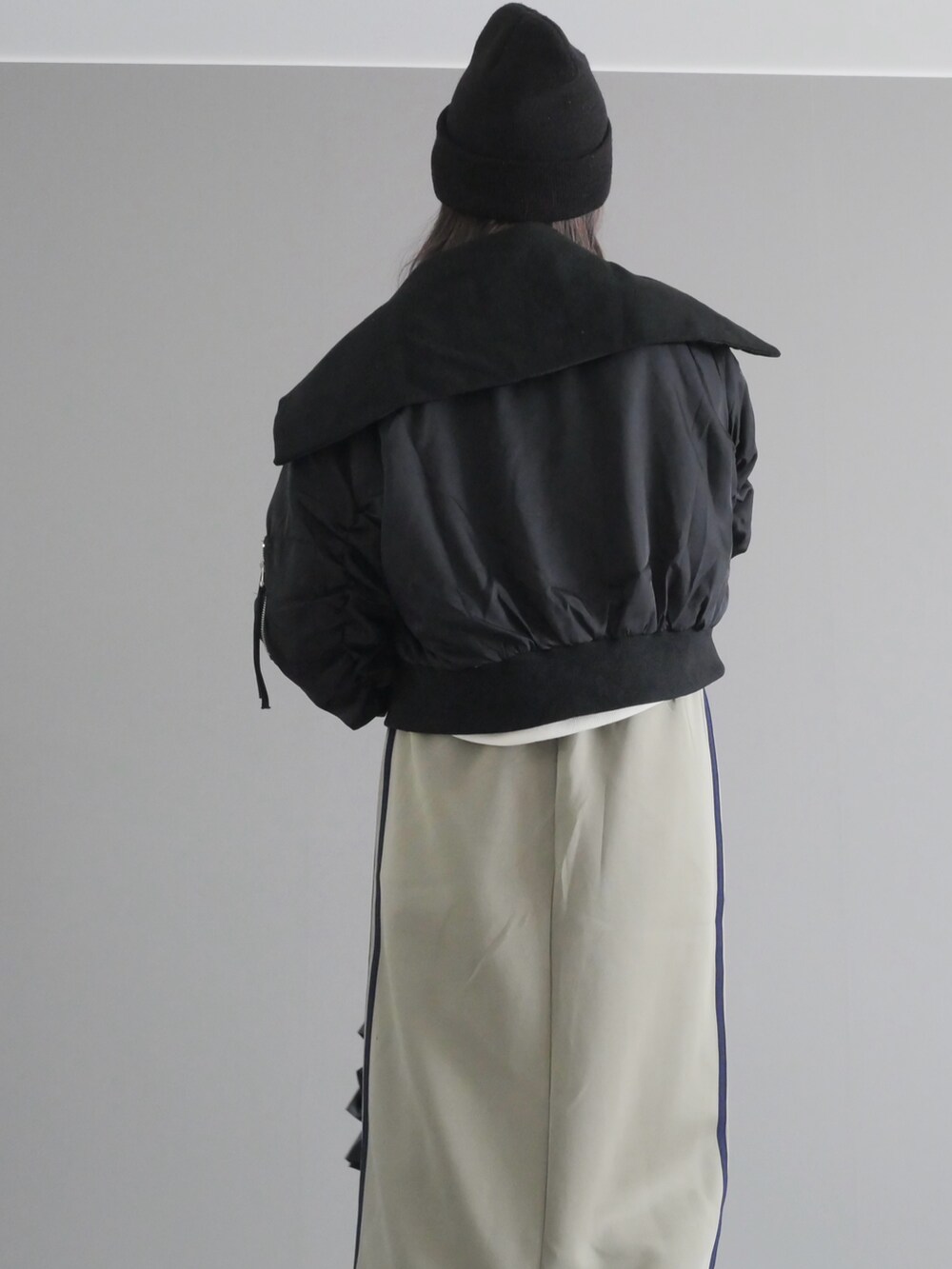 ホワイト系のスウェット、ブラック系のブルゾン、ブルー系のスカートを着用したレディースの秋コーディネートの4枚目の写真