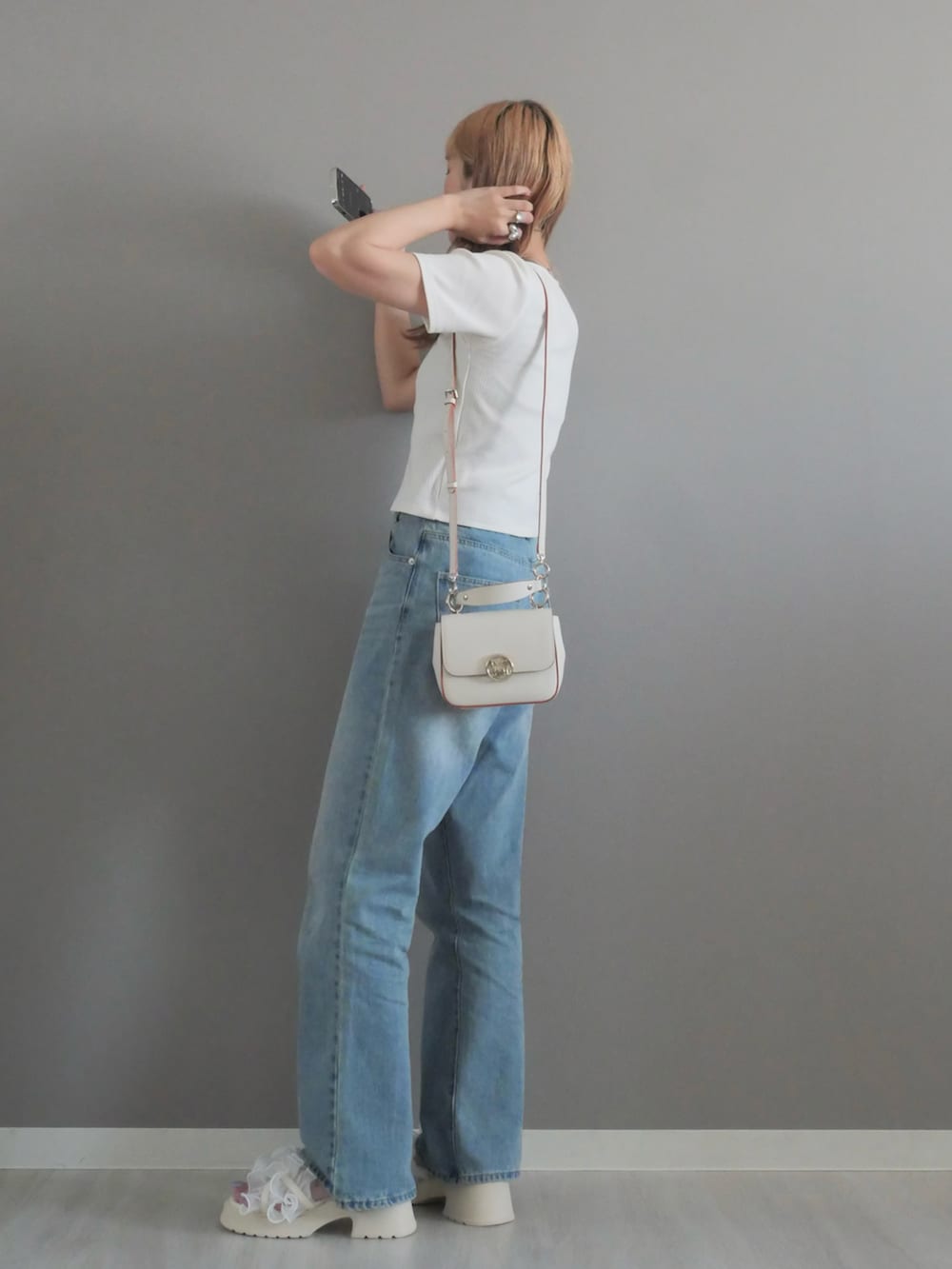 ホワイト系のハンドバッグ、ホワイト系のサンダル、ホワイト系のTシャツ/カットソーを着用したレディースの夏コーディネートの3枚目の写真