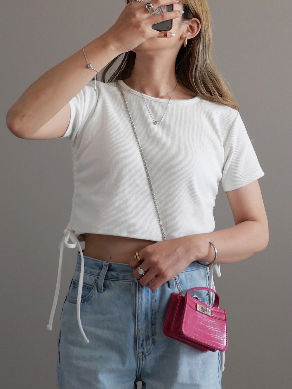 ホワイト系のTシャツ/カットソー、グレー系のデニムパンツ、ピンク系のショルダーバッグを着用したレディースの夏コーディネートの2枚目の写真