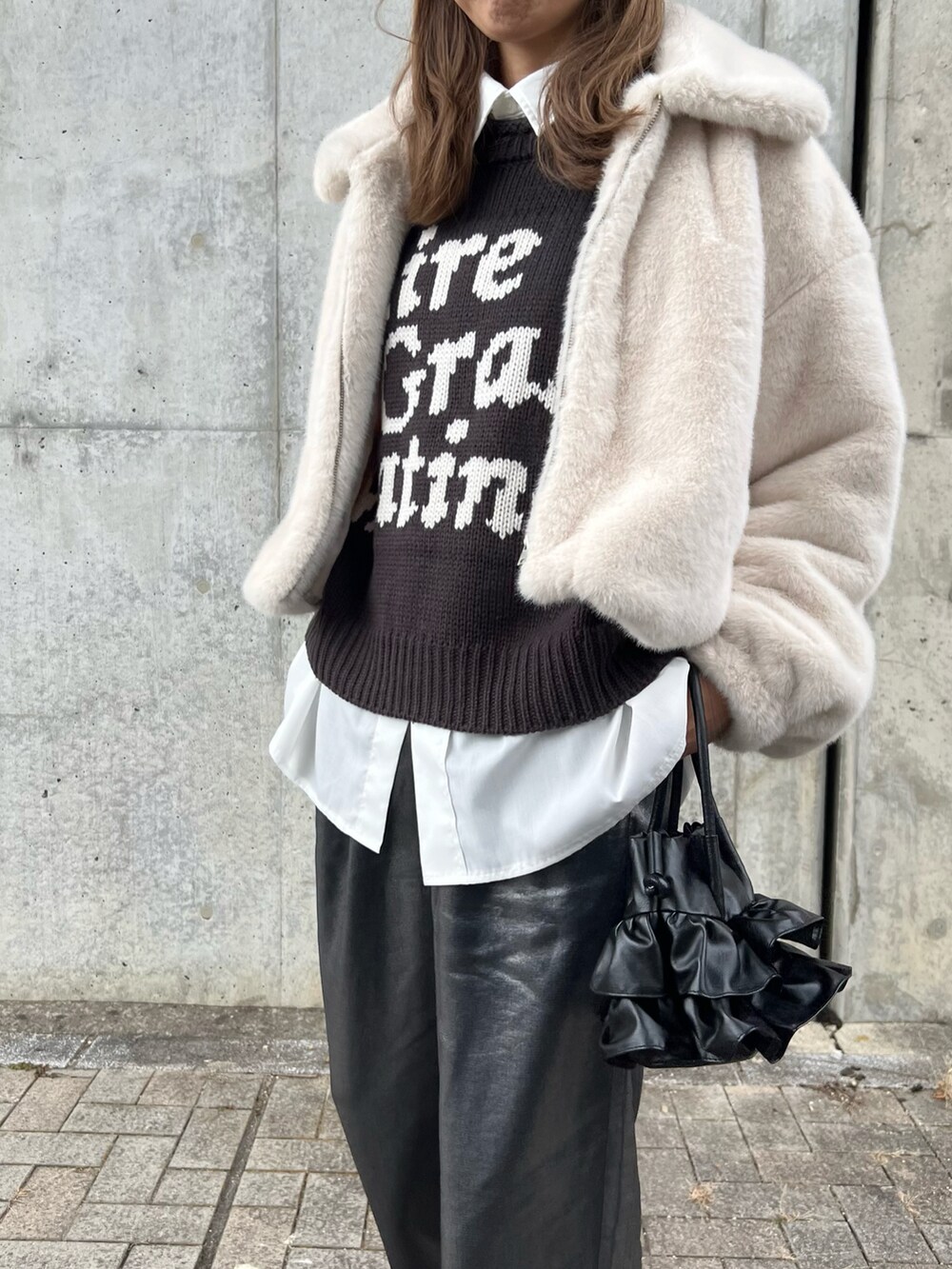 ホワイト系のジャケット/アウター、グレー系のニット/セーター、ホワイト系のシャツ/ブラウスを着用したレディースの冬コーディネートの2枚目の写真