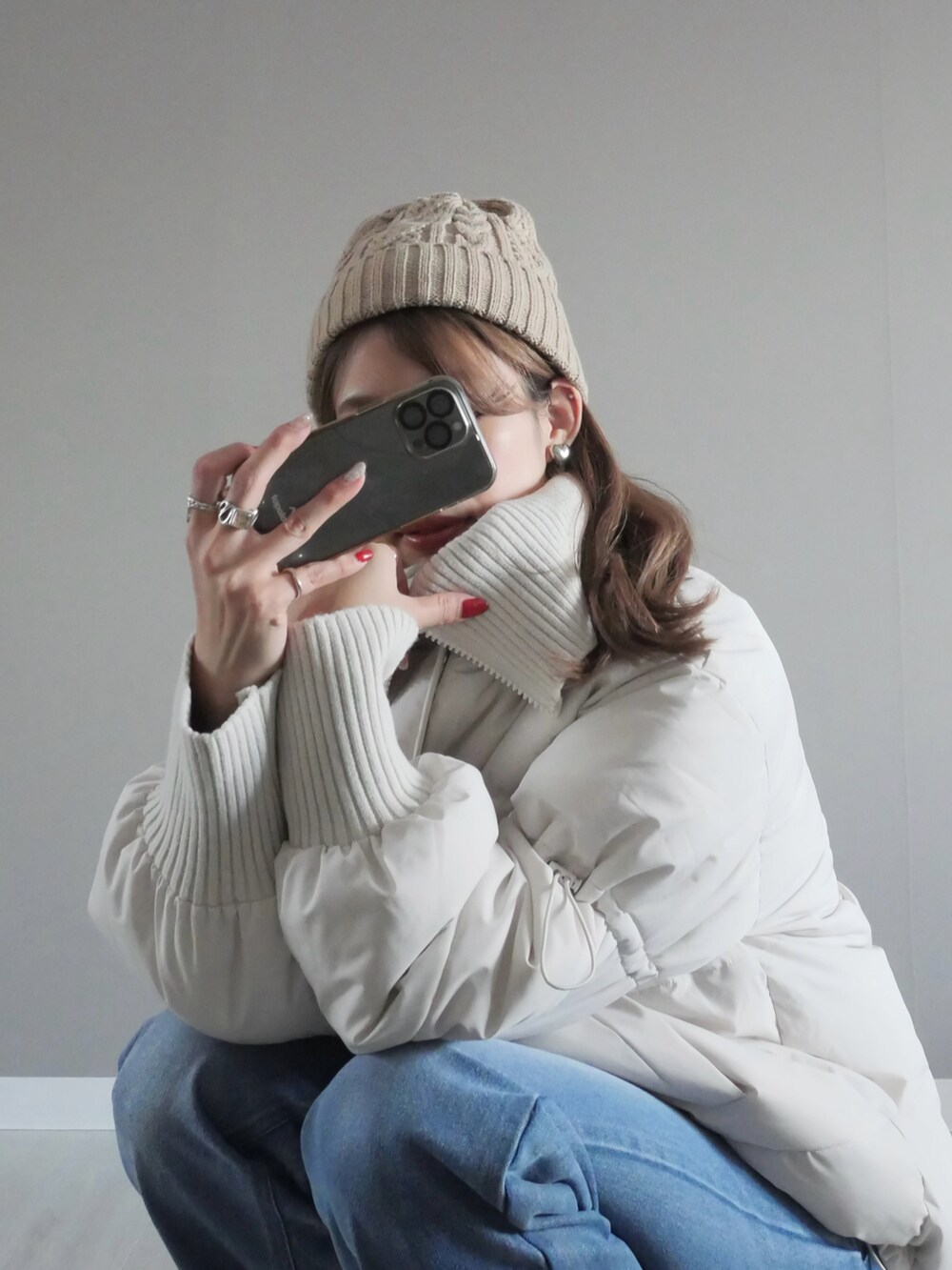 ホワイト系のダウンジャケット/コート、ブルー系のデニムパンツ、ホワイト系のショルダーバッグを着用したレディースの冬コーディネートの3枚目の写真