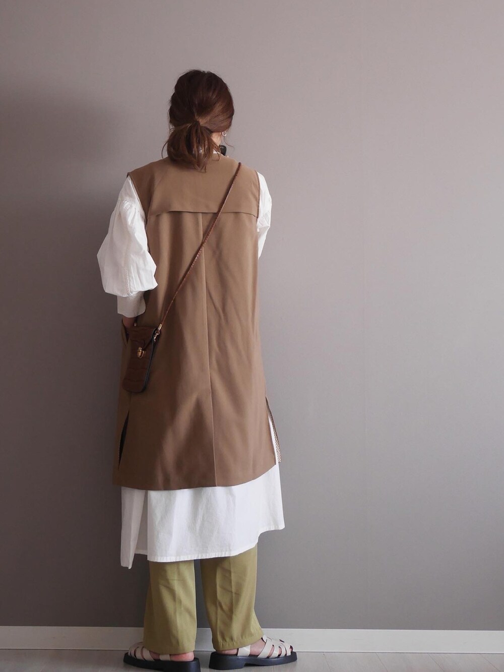 ホワイト系のシャツワンピース、グリーン系のスラックス、ブラウン系のノーカラージャケットを着用したレディースの春コーディネートの3枚目の写真