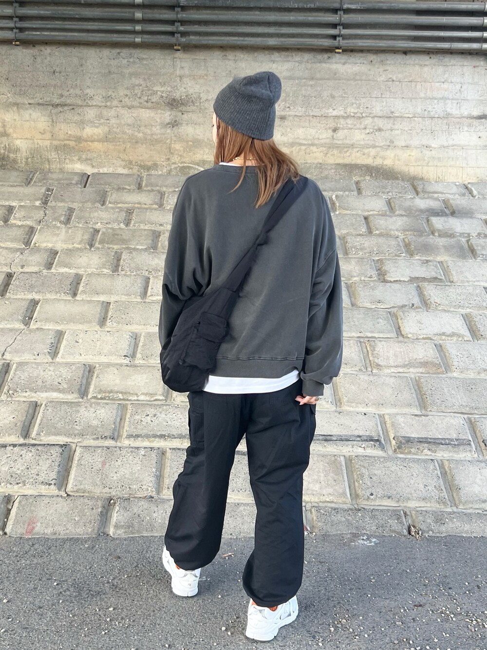 ブラック系のスウェット、ブラック系のカーゴパンツ、ブラック系のショルダーバッグを着用したレディースの秋コーディネートの4枚目の写真